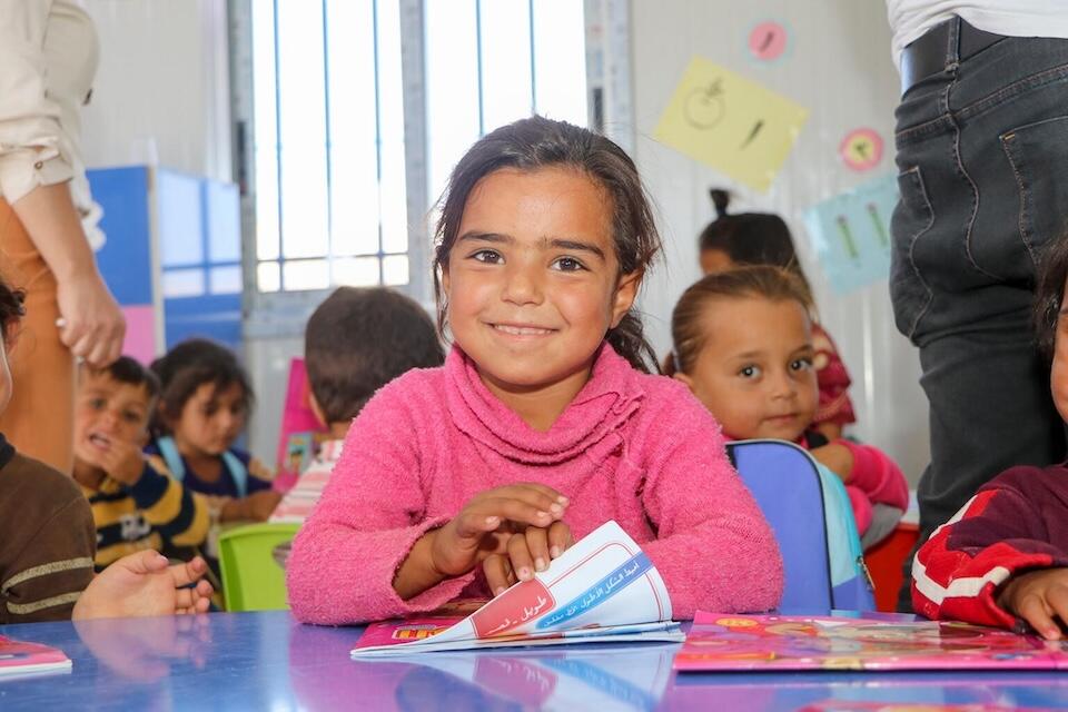 A young girl smiles during an activity at a UNICEF-supported early childhood learning center in Ain Khadra camp in Al-Malikiyeh, Al-Hasakeh, northeast Syria, on Sept. 21, 2023.